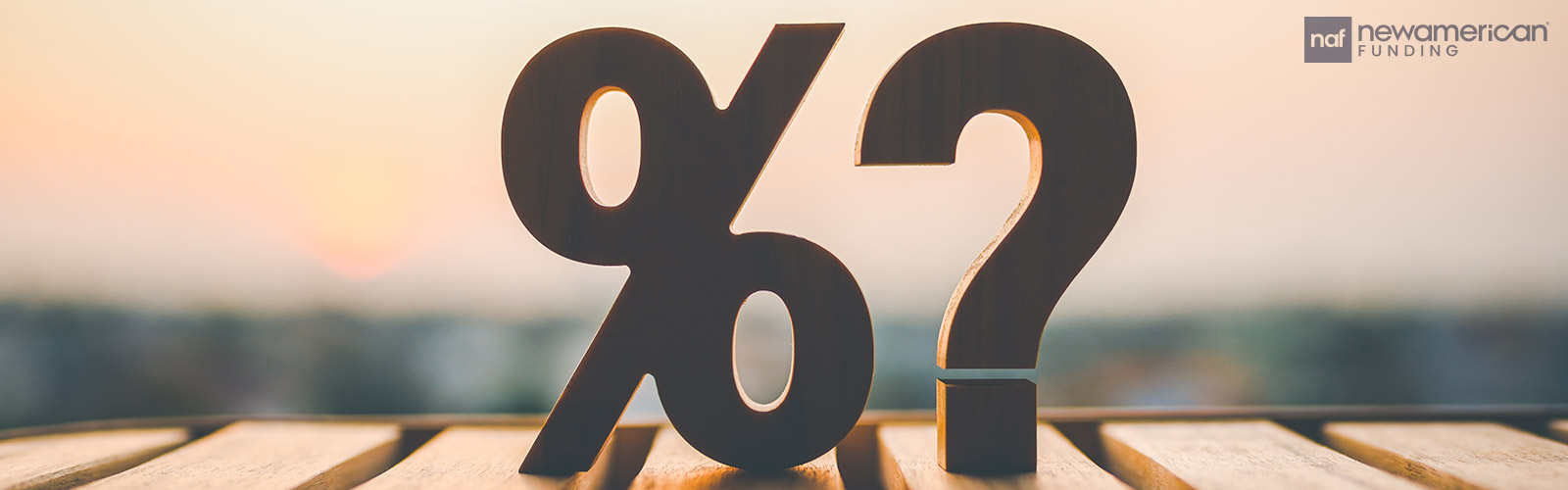 A Black woman and Black man sit together on a couch talking and smiling at a laptop