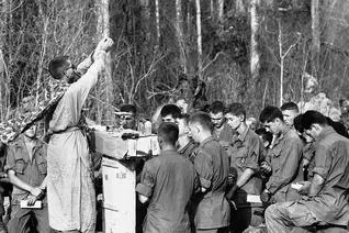 Army Chaplain (Maj.) Charles Watters elevates the host during a Holy Week liturgy for paratroopers of the 173rd Airborne Brigade in Vietnam in March 1967. (AP Photo/Horst Faas)