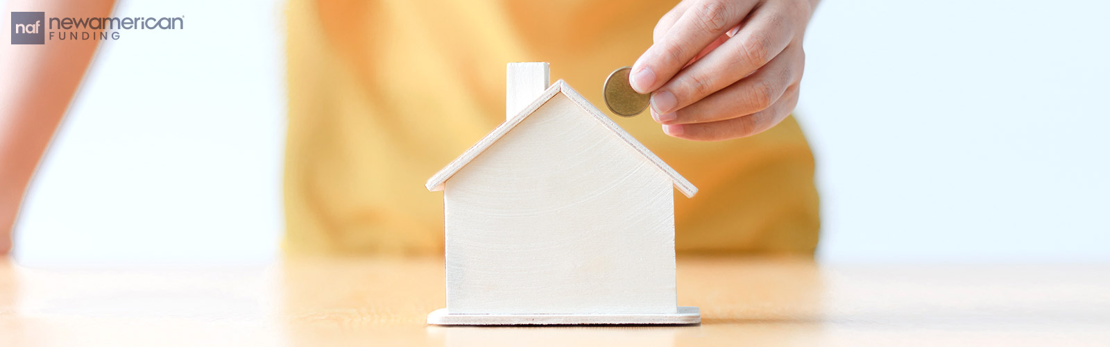 putting a coin in a house piggy bank