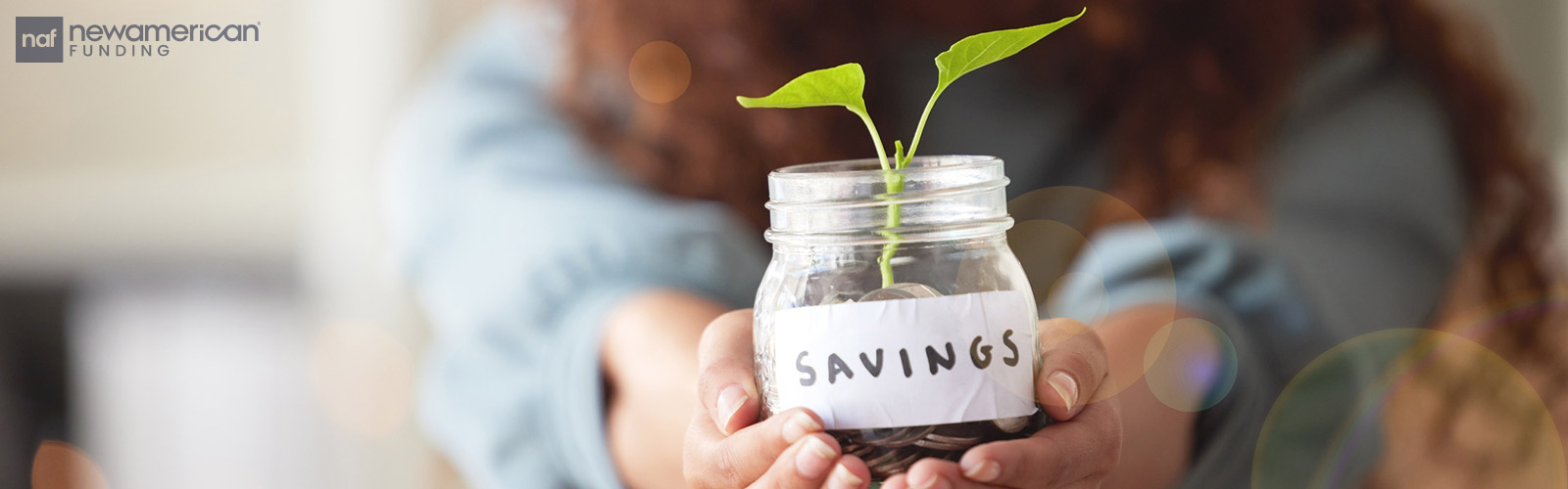 woman holding a saving jar with a plant growing from it