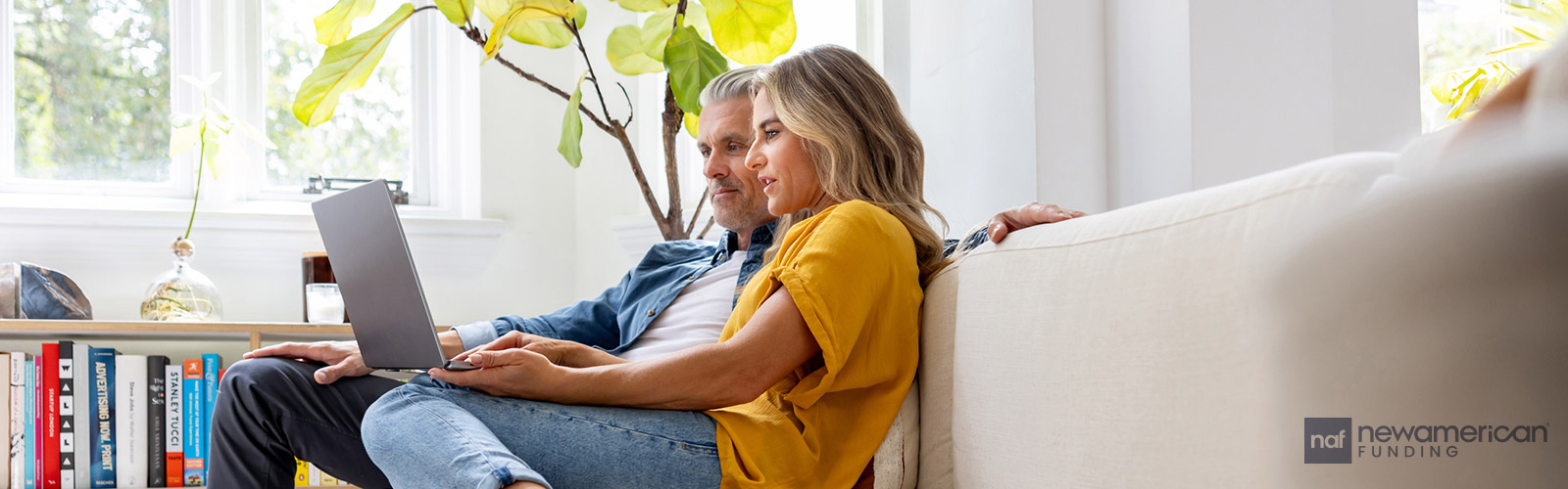 couple on the couch with their laptop