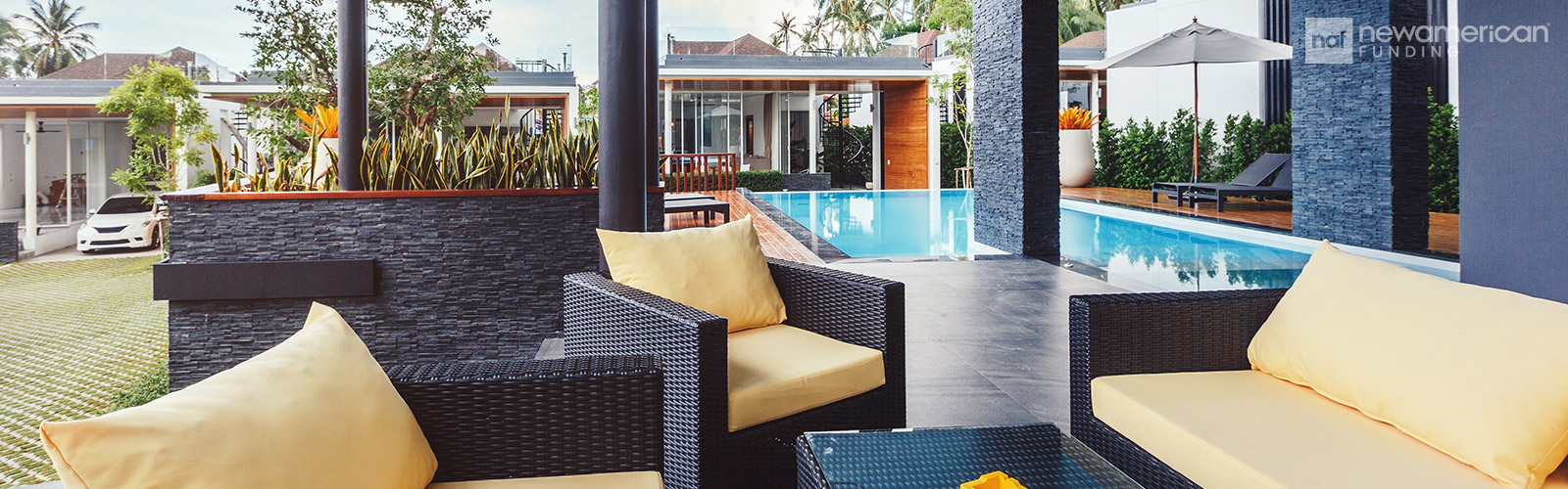 An nice outdoor patio with a pool and stone patio 