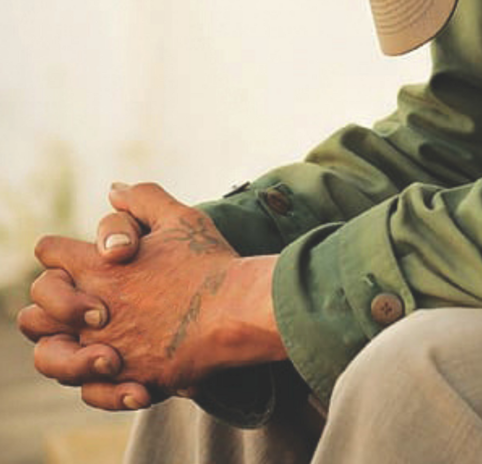 Close-up of a person’s clasped hands, symbolising the urgent need for safe and secure housing in Australia.