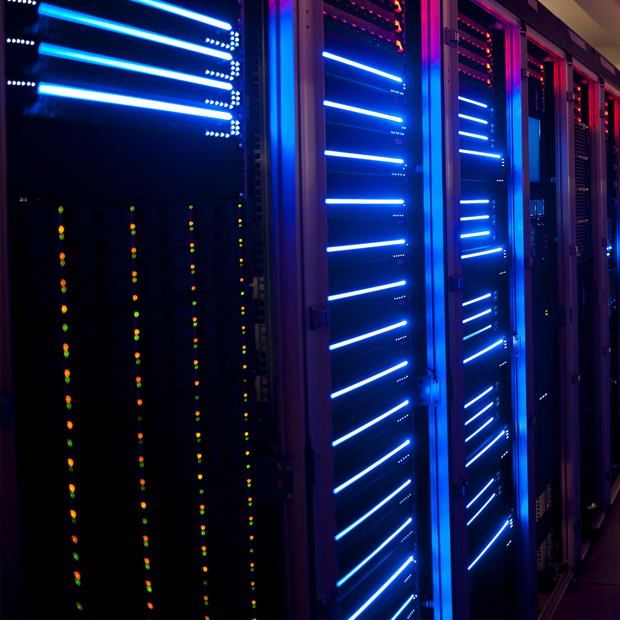 Rows of illuminated data servers with glowing blue and red lights in a technology data center