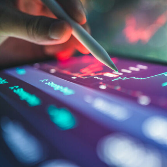 Close-up of investor reviewing financial reports on tablet