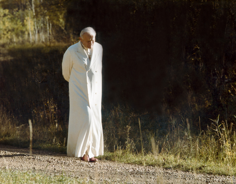 Pope John Paul II walks down a gravel path