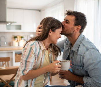 Mlad par sproščeno uživa jutranjo kavo - svojo prihodnost sta zavarovala z naložbenim zavarovanjem.