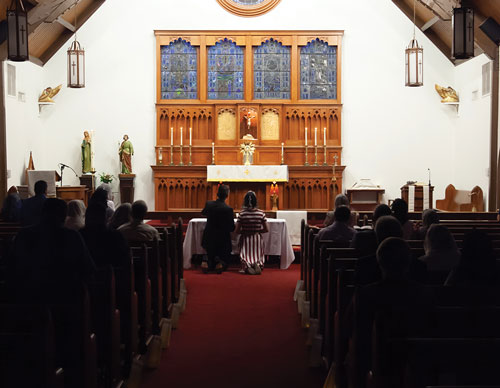 Luis Rosas and his wife, Sandra, kneel before the exposed Eucharist at Incarnation Catholic Church