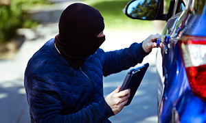 Lopov poskuša vdreti v parkiran avto - Simbolna slika o zavarovanju avta pred krajo