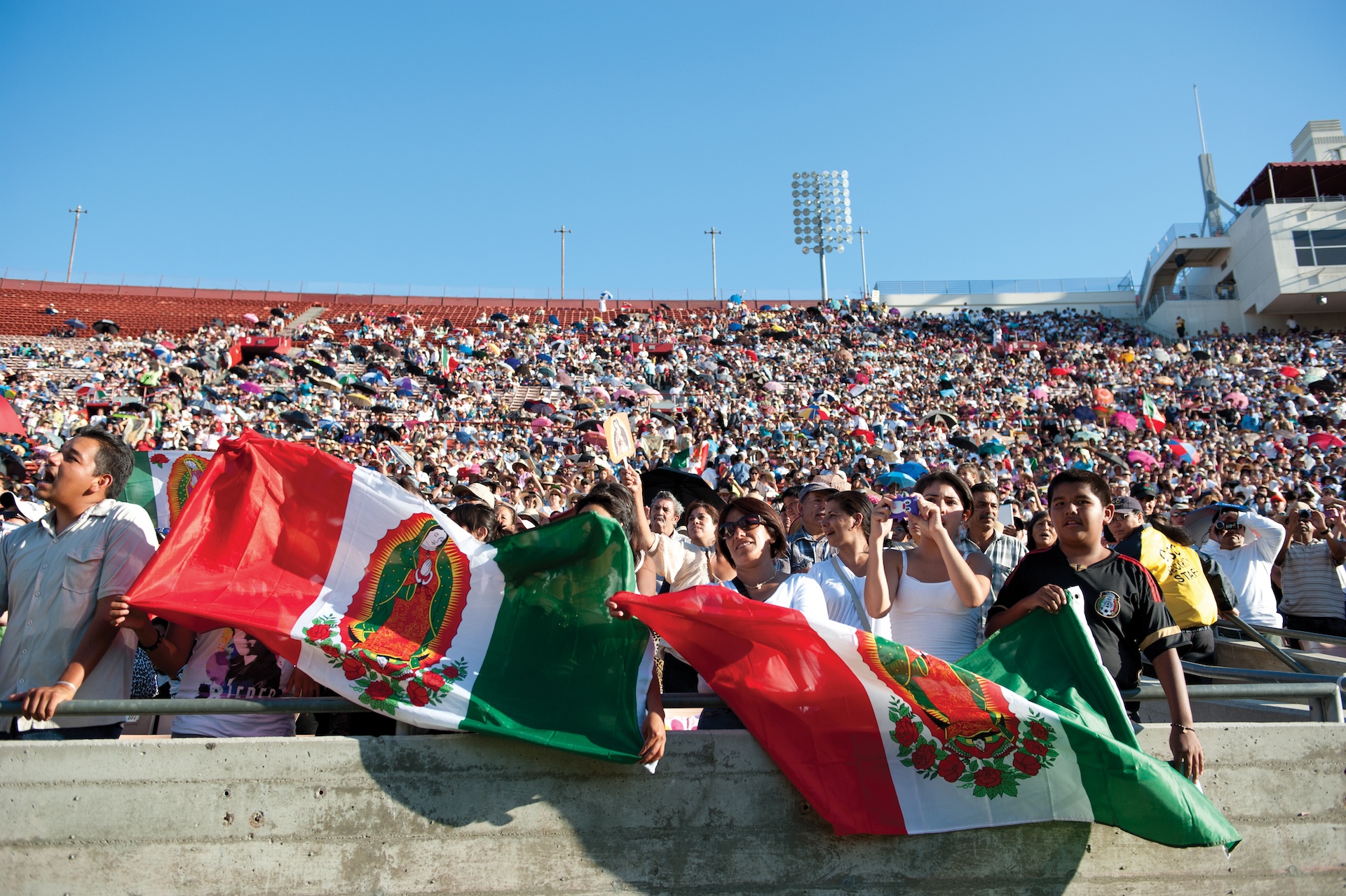 Guadalupe Celebration participants at the Los Angeles Memorial Coliseum Aug. 5, 2012, hold flags of Mexico featuring the image of Our Lady of Guadalupe.