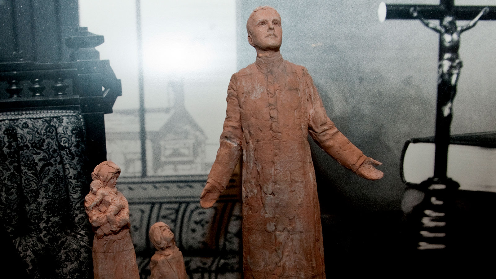 Small Statue of Father Mcgivney with a mother and her children.