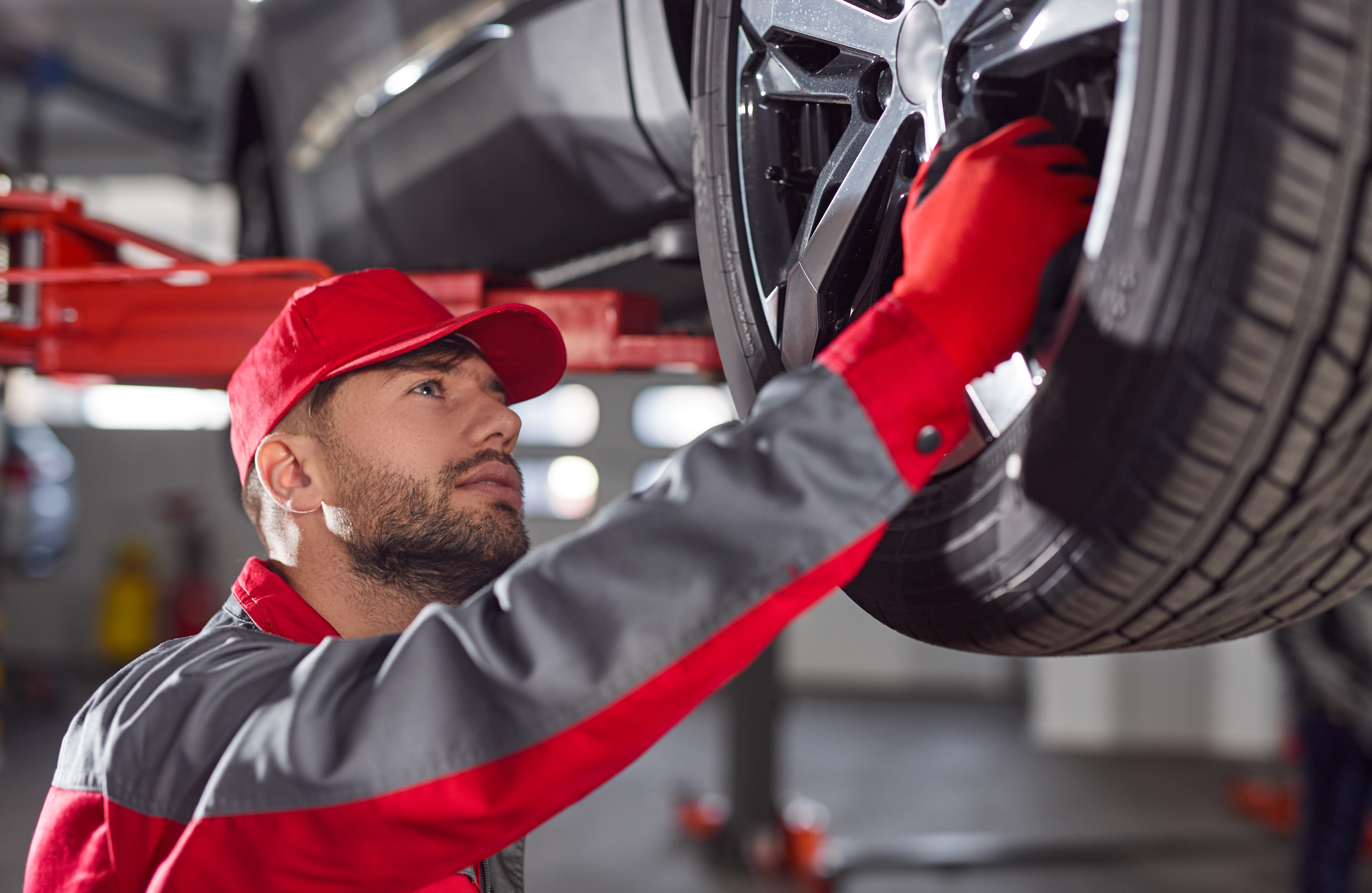 mechanic-repairing-car-wheel-garage.jpg