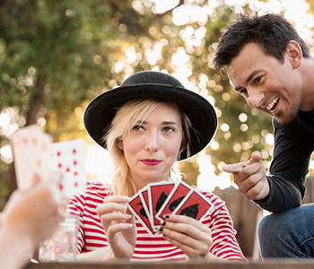 Mladi se zabavajo s kartanjem na vrtu.