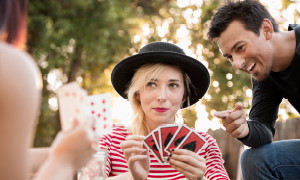 Mladi se zabavajo s kartanjem na vrtu.