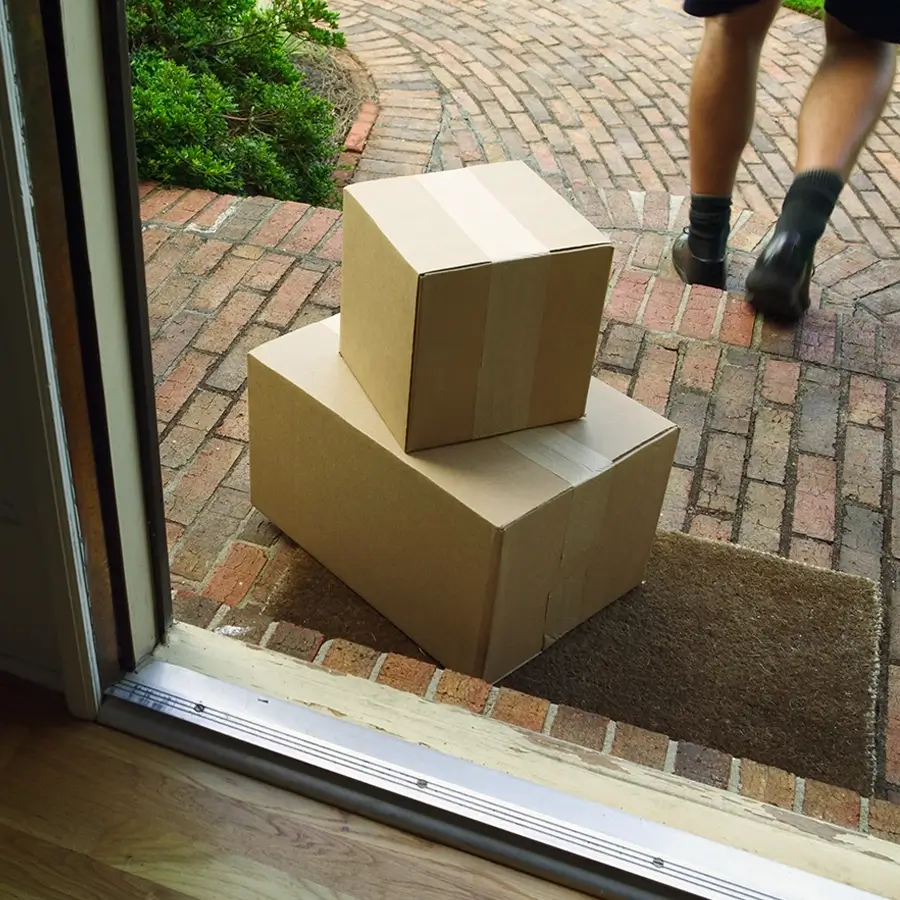 modern-om-cost-optimizer-safeguard-margins-900x900.webp Two cardboard packages delivered and left on a front doorstep, with a delivery person walking away on a brick pathway.