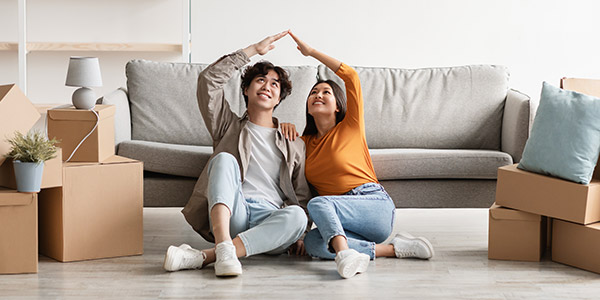 couple making a house shape with their arms