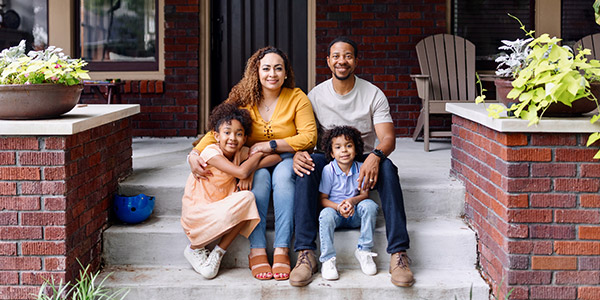 family sitting on the front steps of a house