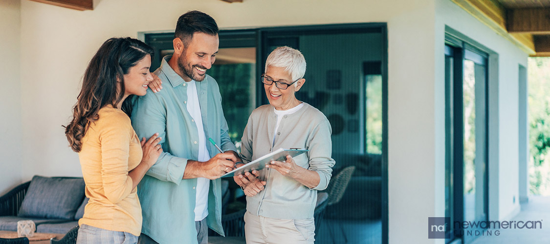 homebuyers signing paperwork with real estate agent