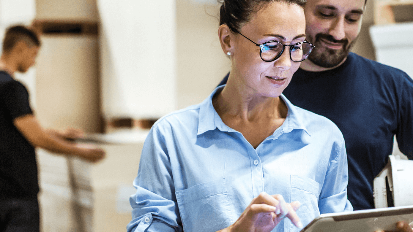 Image of a woman and man looking at a electronic tablet.