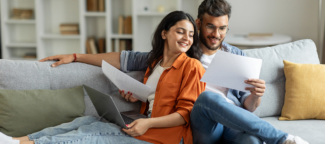 Homeowners looking confident with papers in front of them