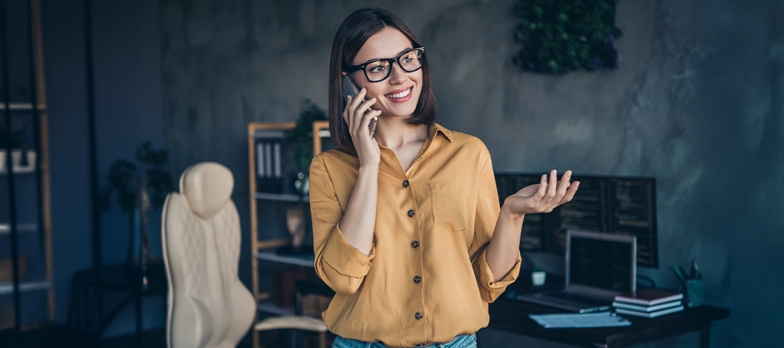 A woman smiling and talking on the phone