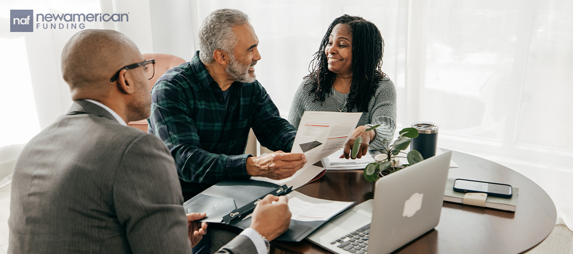 A couple talking to a real estate professional.