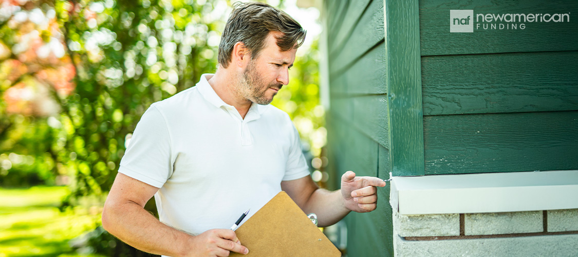A man inspecting the exterior of a home.