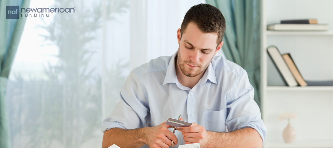 A man cutting up a credit card.