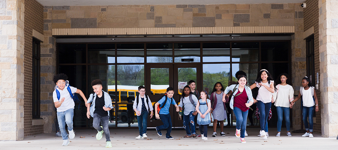 Young children leaving a school