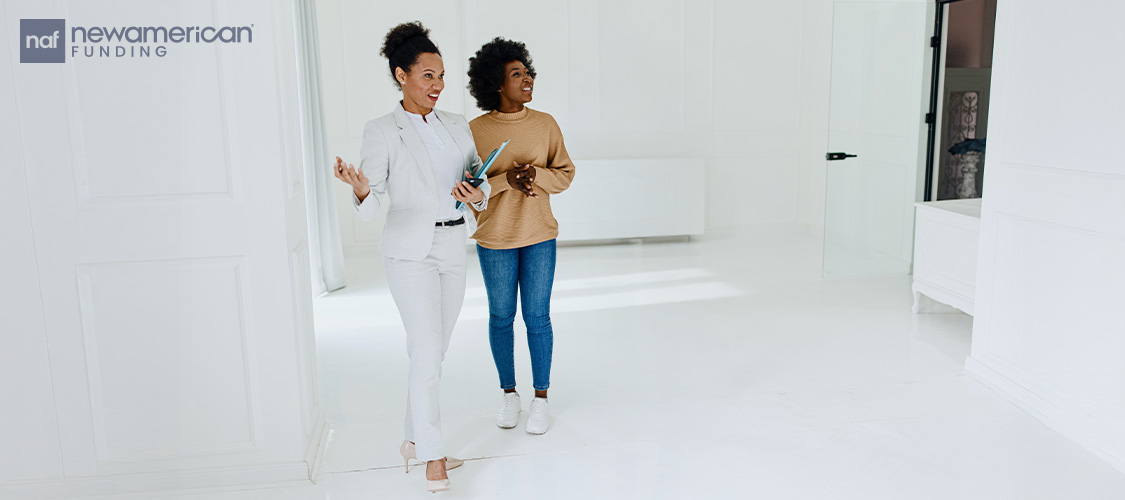 Two women touring a home. 