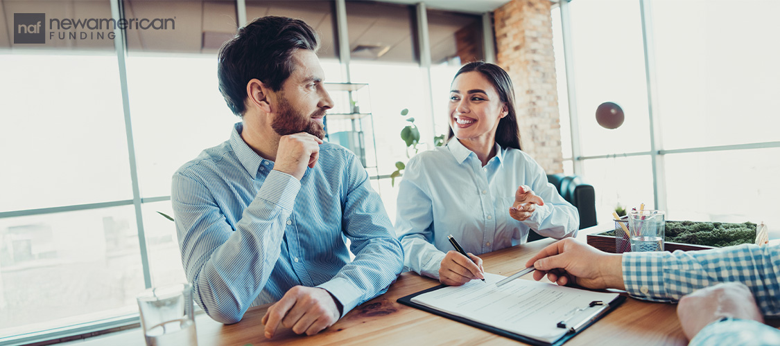 A couple sitting at a desk across from a professional.