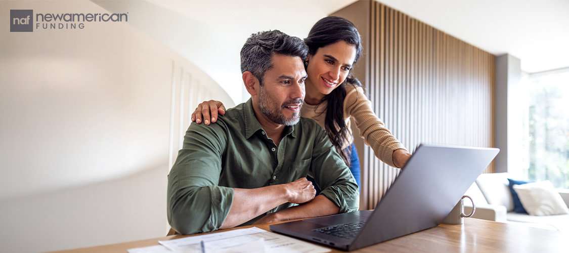 A couple looking at a laptop.