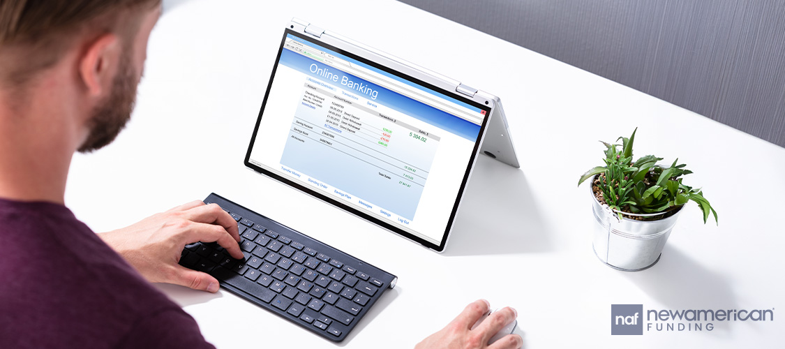 Someone looking at a bank statement on a laptop.