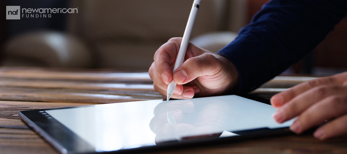 Someone signing a document on a tablet.