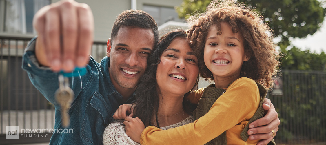 Parents and a children holding up keys.