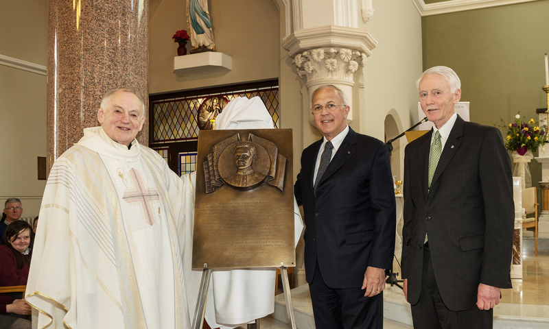 Supreme Knight Carl Anderson presents a plaque, with an image of Father McGivney to Michael Quinn, pastor of St. Mary’s Church.