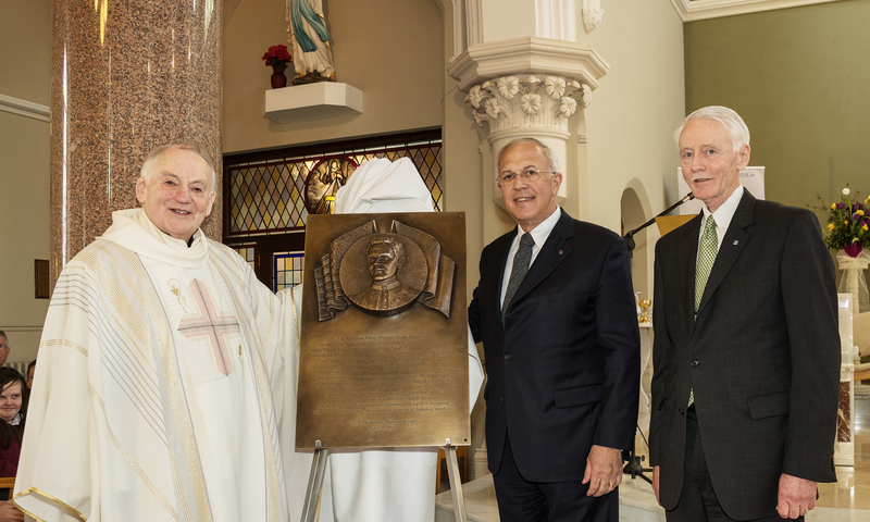Supreme Knight Carl Anderson presents a plaque, with an image of Father McGivney to Michael Quinn, pastor of St. Mary’s Church.