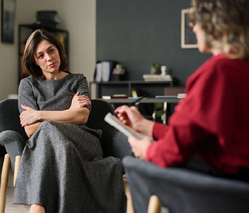 Zaskrbljena pacientka med pogovorom s terapevtko.