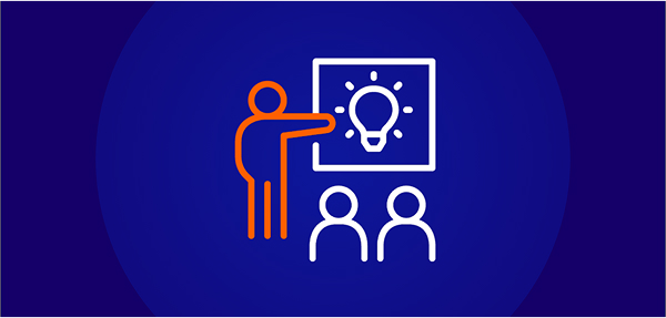A white and orange line-art icon on a dark blue background showing a stylized person with an orange outline presenting a whiteboard with a lightbulb icon to two attendees, symbolizing accredited learning or teaching.