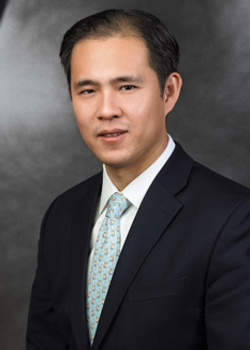 Headshot of Richard Lee, who smiles while wearing a black suit and a teal tie