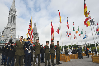 American service members participate in a military ceremony outside the Basilica of Our Lady of the Rosary