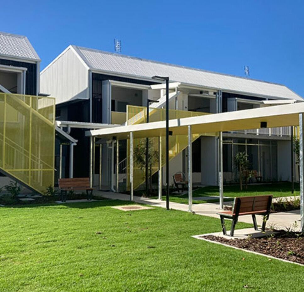 Exterior view of Mission Australia's Townsville Youth Foyer with landscaped gardens and modern apartments.