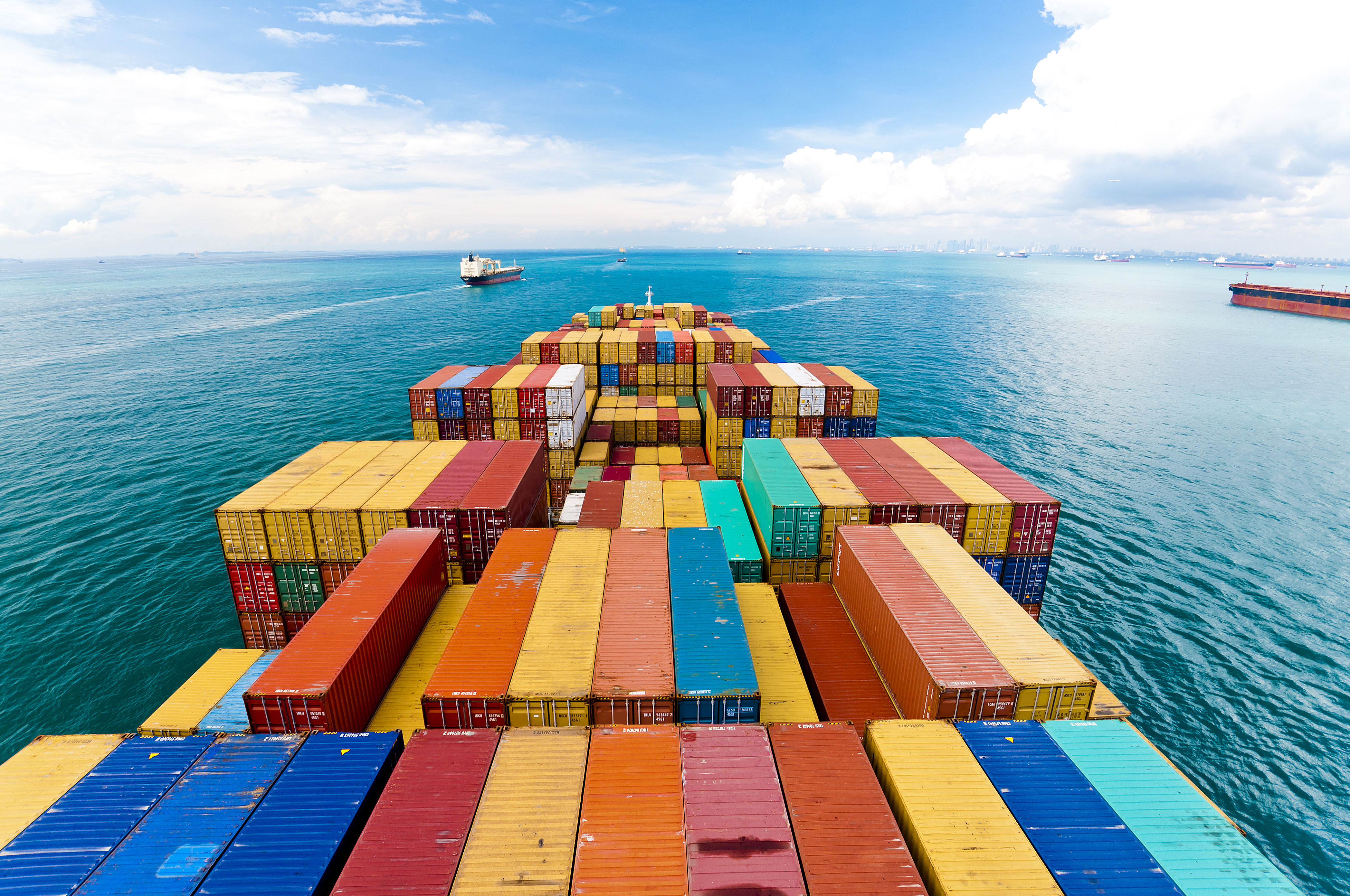 Large freight ship carrying many containers, traversing through the ocean