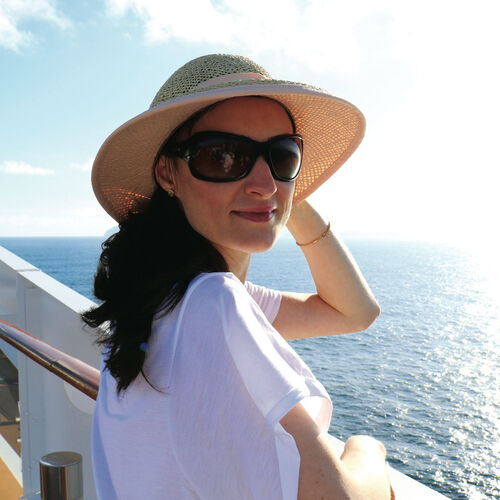 Mujer con sombrero de paja y gafas de sol polarizadas HOYA mirando el océano