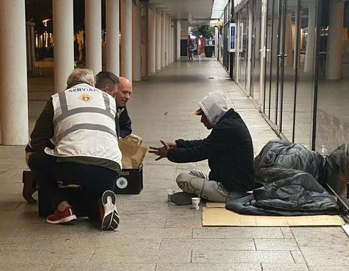 Members of Blessed No&euml;l Pinot Council 16722 in Angers, France , serve breakfast to a man experiencing homelessness.