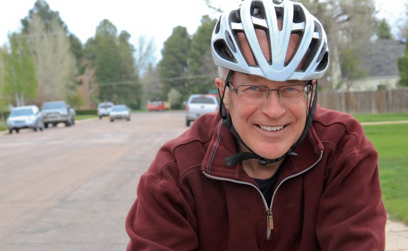 Moški srednjih let se zadovoljen vozi s kolesom, na glavi ima kolesarsko čelado. Zastoj srca bi mu lahko preprečil vrnitev domov.