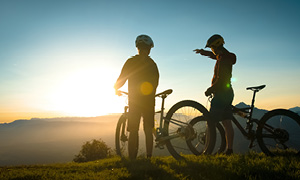 Turna kolesarja na gorski poti STKP s pogledom na slovensko pokrajino v ozadju.
