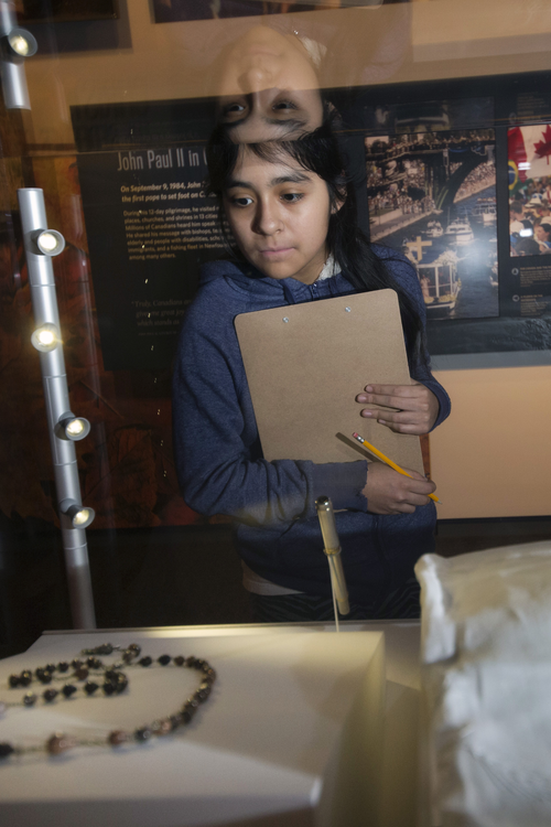 A student views a rosary in the exhibit at the JPII Shrine