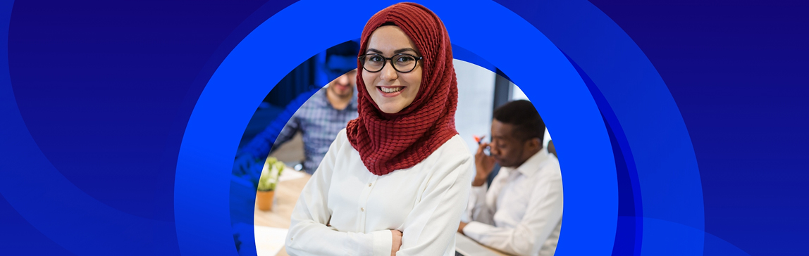 A smiling woman wearing a red hijab and glasses stands in the foreground with her arms crossed. She is wearing a white collared shirt. In the blurred background, two men are seated at a table, suggesting an office or study environment. The entire image is framed by a dynamic, abstract dark blue background with concentric circles.