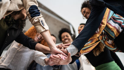 Group of co-workers put their hands all in